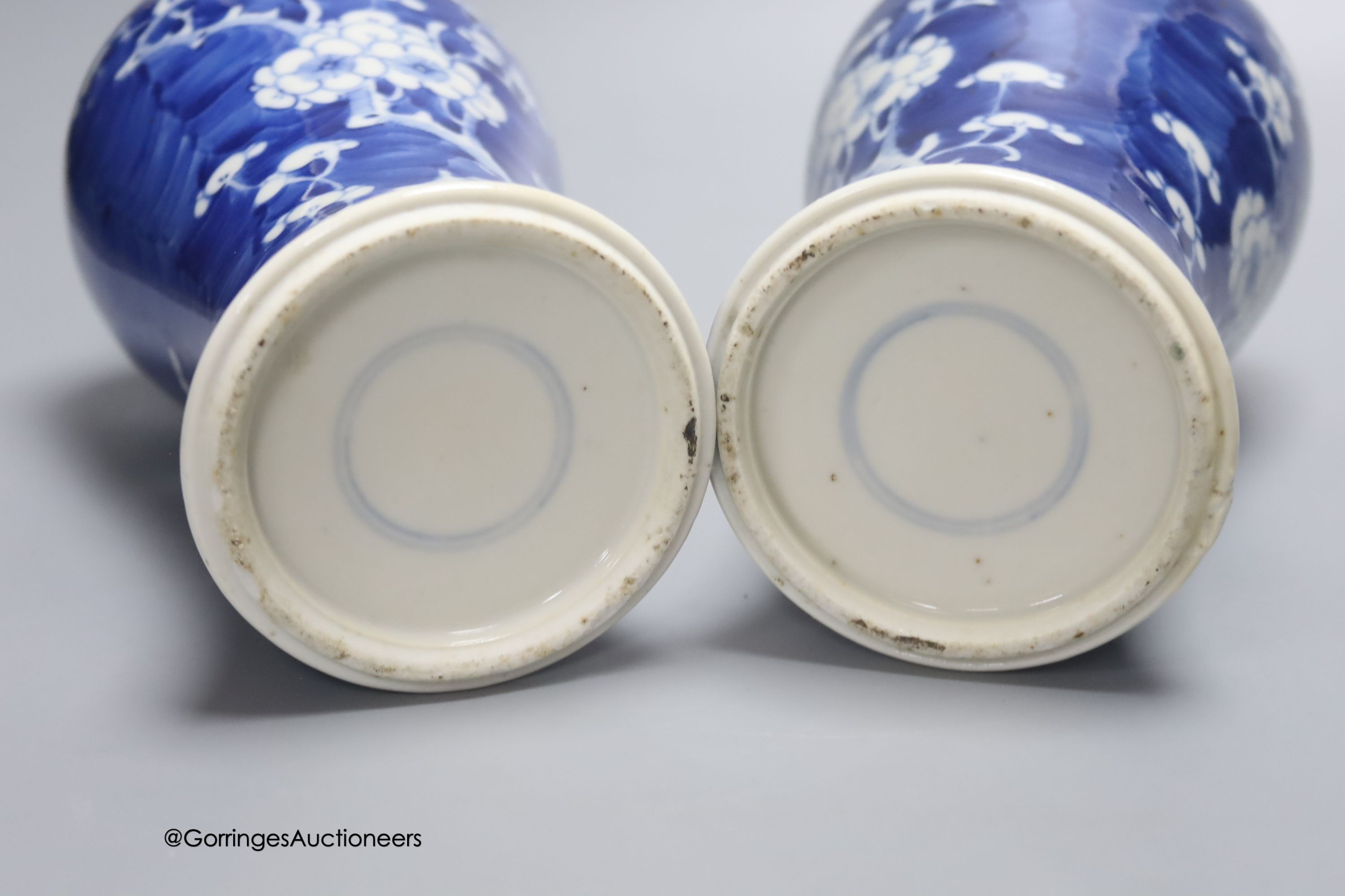 A pair of early 20th century Chinese blue and white prunus vases and covers, height 30cm